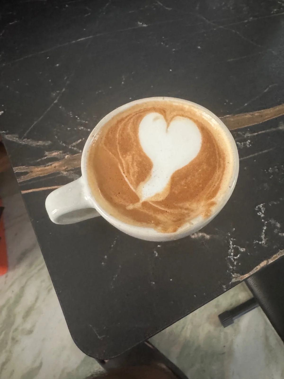 A white heart-shaped latte-art pour in a homemade milk coffee